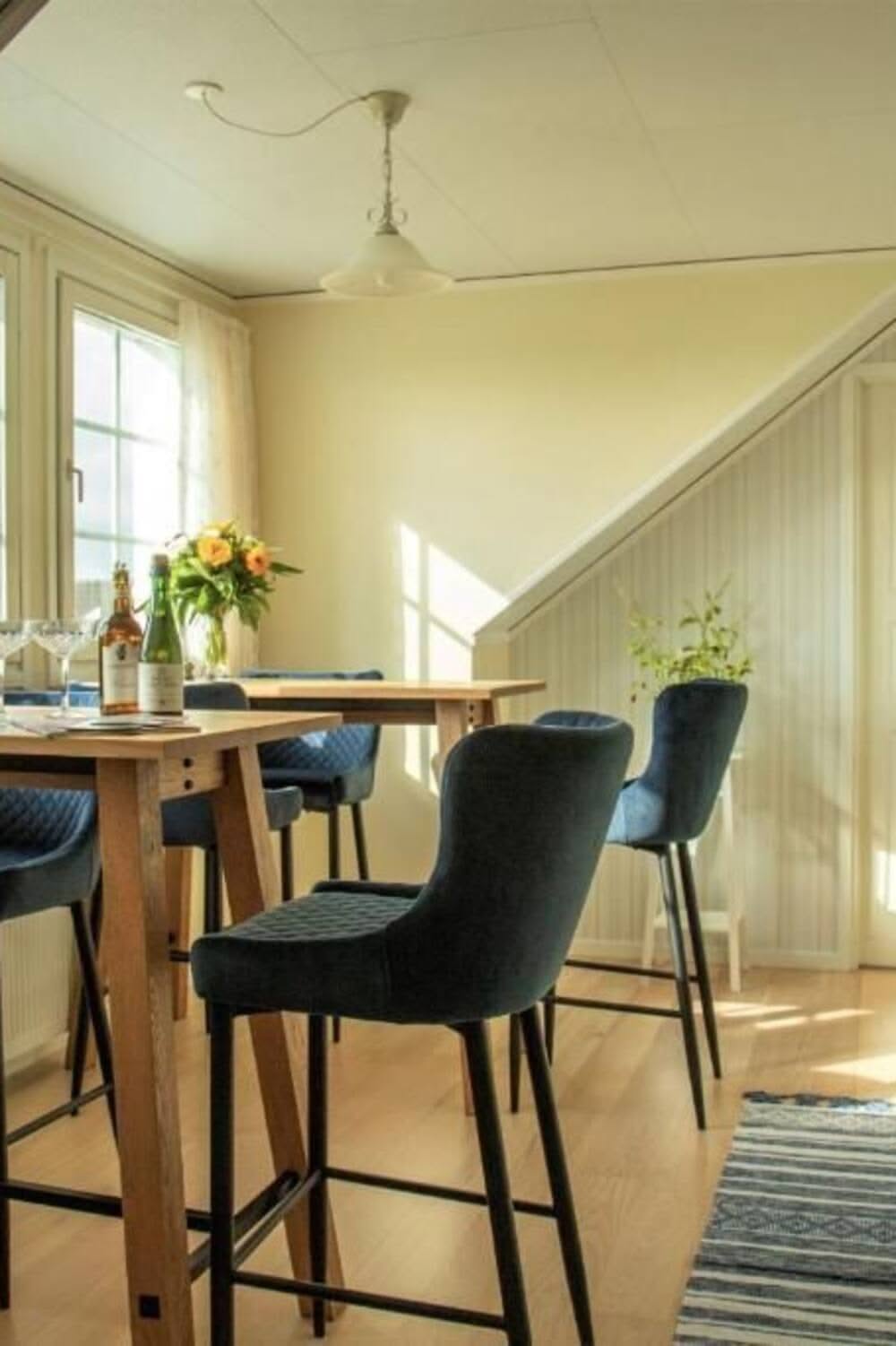 Cozy Dining Nook With Blue Velvet Chairs and Sloped Ceiling