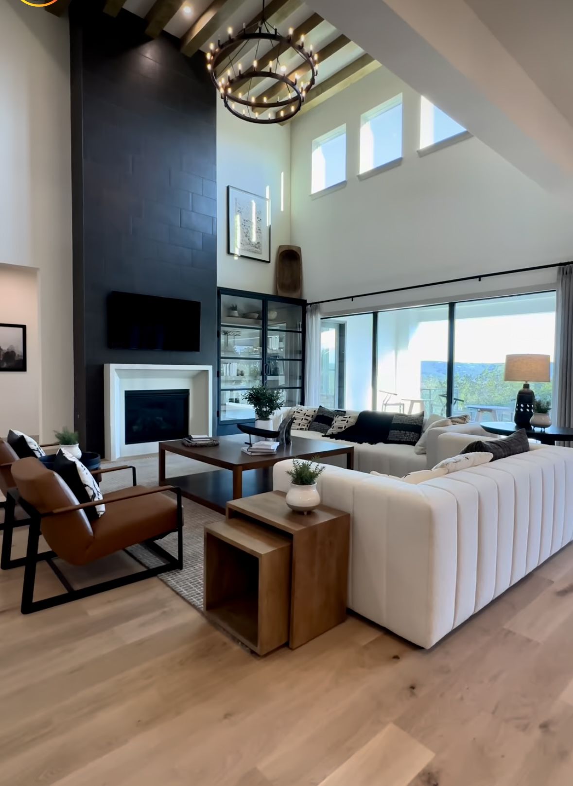 Modern Living Room With Double-Height Ceiling and Black Fireplace Feature
