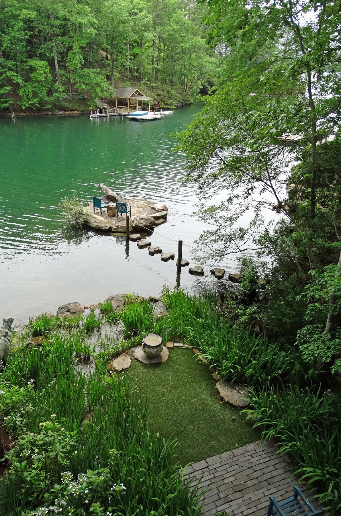 Lakeside garden with stone path and dock view