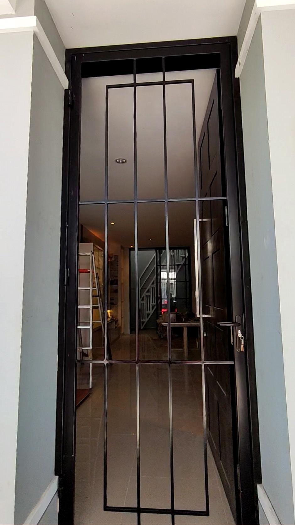 Modern Black Steel Security Door with Vertical Bars at Home Entry