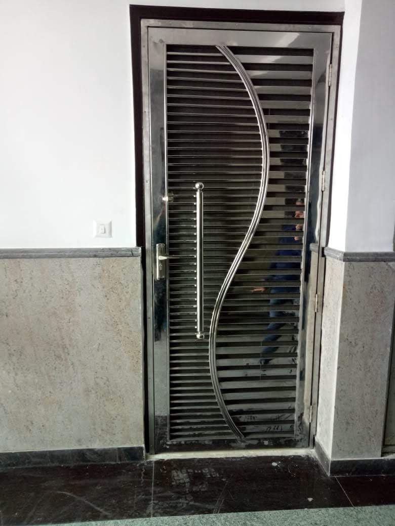 Modern Steel Security Door with Curved Handle in Interior Hallway